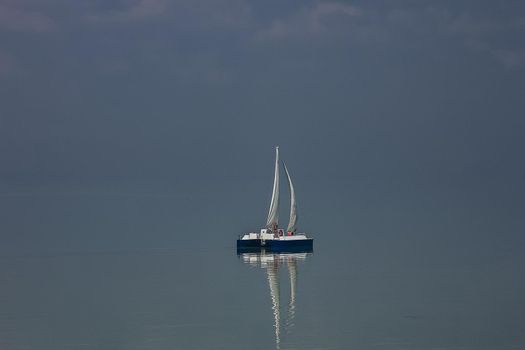A beautiful sky with a boat in the sea with clouds over.