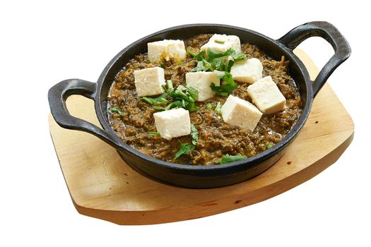 Overhead  shot of Palak paneer baked in little pan. Isolated on white with clipping path