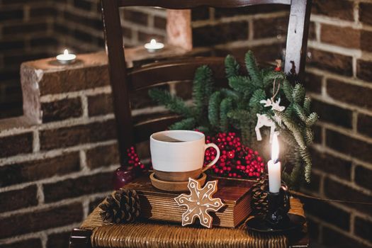 Christmas hot chocolate with mini marshmellows in an old ceramic mug with candles on a wooden background.