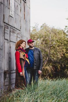 Happy couple in love embraces and has fun outside in the nature background. Woman is pregnant. Happy new parents