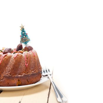 Christmas cake donut with tree as festive decoration on top over white background