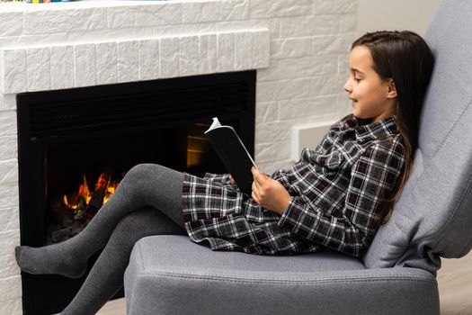 Portrait of a beautiful little girl reading a book.