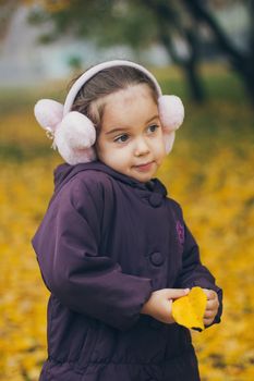 Adorable funny naughty little girl in the park on beautiful autumn day.