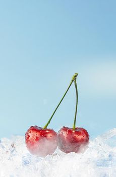two ripe cherries on ice