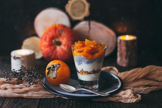 Delicious breakfast: chia seed pudding and persimmon close up in a glass on the table. horizontal.