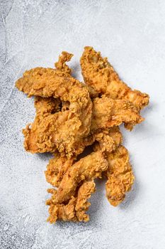 Crispy fried breaded chicken breast strips. White background. Top view.