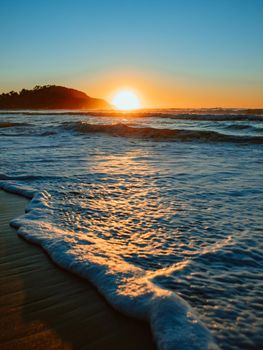 Sunrise on the beach and ocean waves on a tropical sea. High quality photo