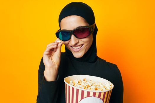 pretty woman in black hijab popcorn 3D glasses cinema ethnicity model. High quality photo