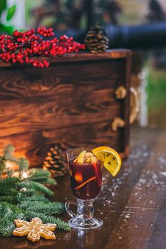 Red hot drink glintwein with spices, cinnamon, anise, fruits, brown sugar on an old wooden table. New Year and Christmas holidays concept. Mulled wine and glintwein