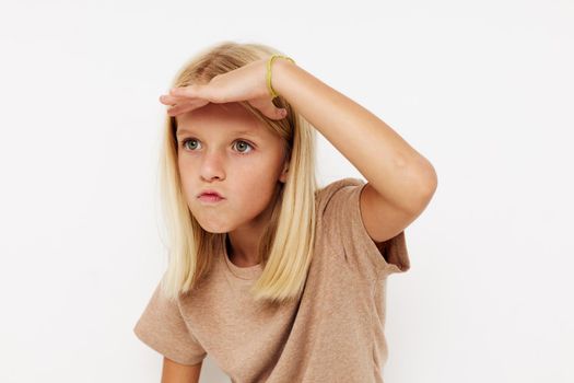 Beautiful little girl gestures with his hands posing studio. High quality photo