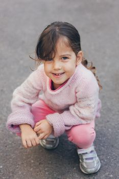 Young girl in a pink sweater and pink leggings in the park.