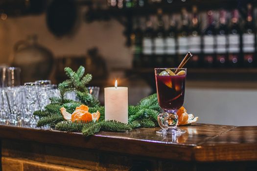 Red hot drink glintwein with spices, cinnamon, anise, fruits, brown sugar on an old wooden table. New Year and Christmas holidays concept. Mulled wine and glintwein