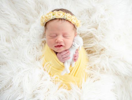 newborn girl in diadem holding toy