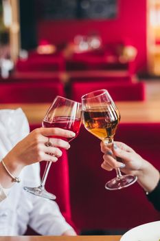 Cheers my friend. Girlfriends drinking wine while sitting in the restaurant after quarantine is over. Hands only.