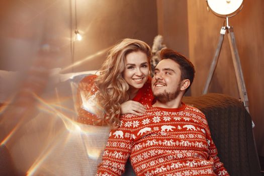 People in a Christman decorations. Man and woman in a red sweater. Family at home.