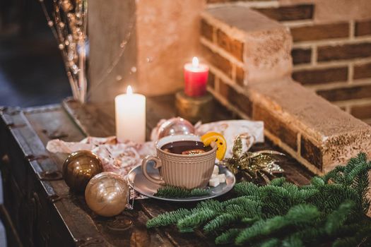 Red hot drink glintwein with spices, cinnamon, anise, fruits, brown sugar on an old wooden table. New Year and Christmas holidays concept. Mulled wine and glintwein