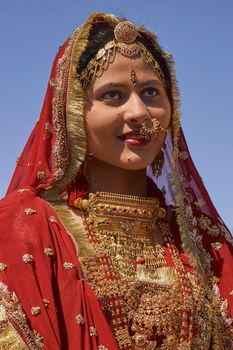 Jaisalmer, Rajasthan, India - February 19, 2008: Indian lady dressed in ornate red sari and adorned with traditional Indian jewellery at the annual Desert Festival in Jaisalmer.