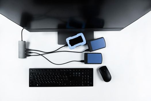 Multiple external hard drives connected to a monoblock on a white background.Computer with hard drive.