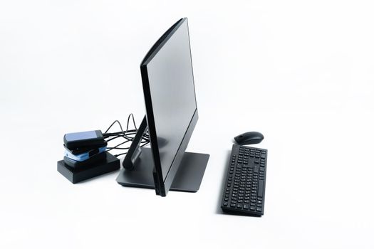 Multiple external hard drives connected to a monoblock on a white background.Computer with hard drive.