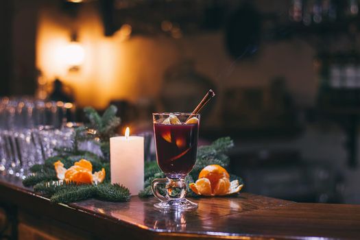 Red hot drink glintwein with spices, cinnamon, anise, fruits, brown sugar on an old wooden table. New Year and Christmas holidays concept. Mulled wine and glintwein