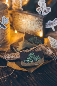 Pieces of beautiful natural handcrafted soap on wooden background with botanical elements, close up view. For relax, health, spa and aromatherapy.