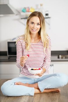 Caucasian woman eating an appetizer with nuts, raspberries and blackberries. Concept of healthy diet.