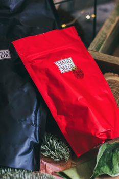 Black and red zip lock packs with hand made contents. Christmas decorations on the grey concrete background