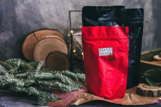 Black and red zip lock packs with hand made contents. Christmas decorations on the grey concrete background