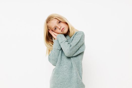 Positive little girl gestures with his hands on a light background. High quality photo