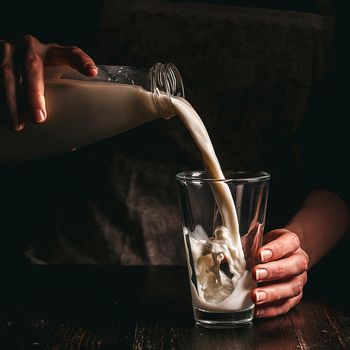 woman farmer with a glass of milk. concept problems in the agricultural sector.