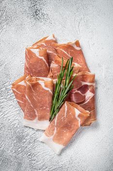 Italian prosciutto crudo parma ham on a table. White background. Top View.