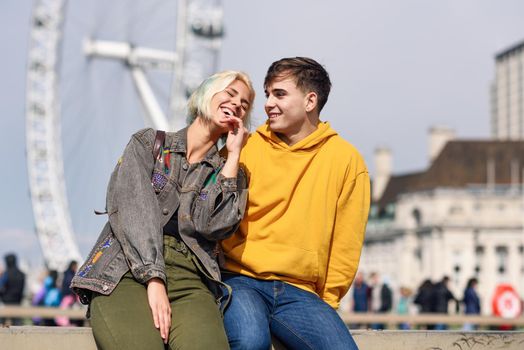 Happy couple by westminster bridge, River Thames, London. UK. Young couple of friends enjoying view during travel.