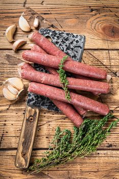 Uncooked Raw beef and pork sausage on vintage meat cleaver. wooden background. Top view.