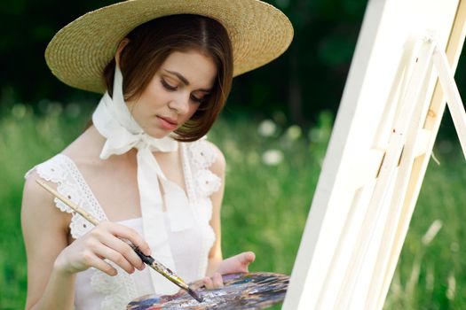 woman artist draws a picture on an easel outdoors. High quality photo