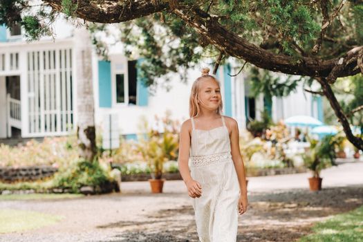 Summer portrait of a happy little girl on the island of Mauritius.beautiful smile, summer white dress