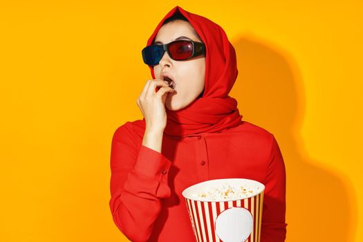 arab woman 3d glasses technology watching movie popcorn yellow background. High quality photo