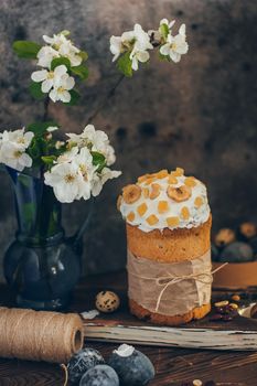 Traditional Russian Orthodox Easter bread kulich with apple blossom and colored eggs