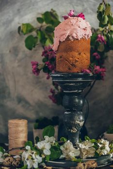 Traditional Russian Orthodox Easter bread kulich with apple blossom and colored eggs