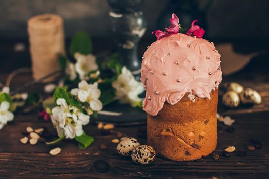 Traditional Russian Orthodox Easter bread kulich with apple blossom and colored eggs