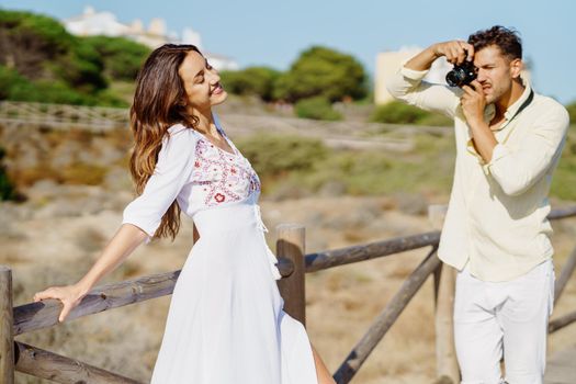 Man photographing his girlfriend on a lovers' trip Couple enjoying a natural environment.