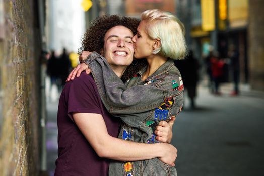 Happy couple hugging in urban background on a typical London street. UK.