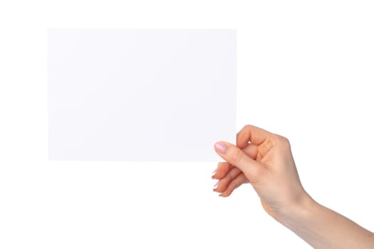 Woman's hand holding blank white sheet of paper isolated on white background