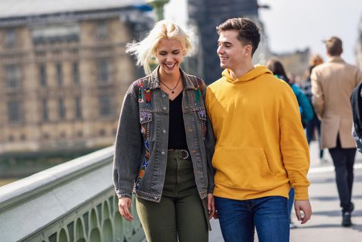 Happy couple by westminster bridge, River Thames, London. UK. Young couple of friends enjoying view during travel.