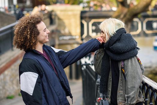 Happy couple having fun un Camden Town Little Venice, London. UK. Young woman kissing the hand of her boyfriend.