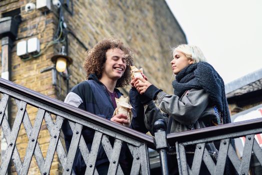 Happy couple eating Doner kebab, shawarma, in Camden Town, London. UK