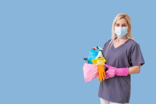 Young smiling cleaner woman. Isolated over blue background.