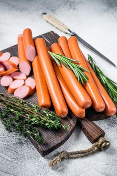 German raw Frankfurter sausages on a wooden board. White background. Top view.