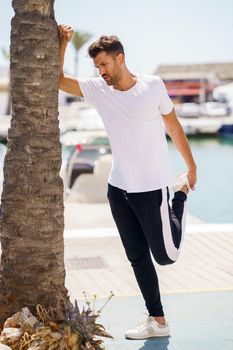 Young man stretching after exercise in a harbour