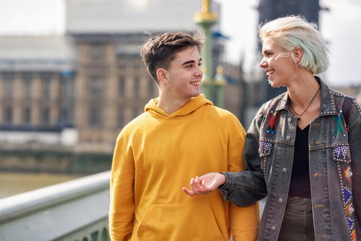 Happy couple by westminster bridge, River Thames, London. UK. Young couple of friends enjoying view during travel.