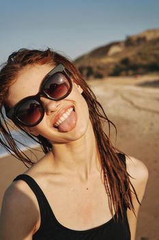 cheerful woman sunglasses posing black swimsuit island. High quality photo